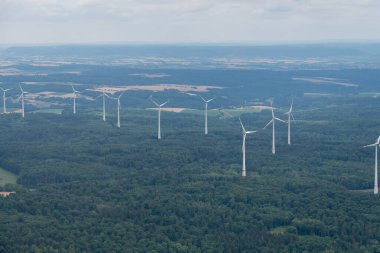 Moeckmuehl, Wurttemberg, Germany, July 11, 2022 Wind energy stations in a green forest seen from a small plane