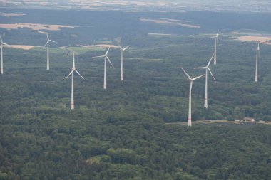 Moeckmuehl, Wurttemberg, Germany, July 11, 2022 Wind energy stations in a green forest seen from a small plane