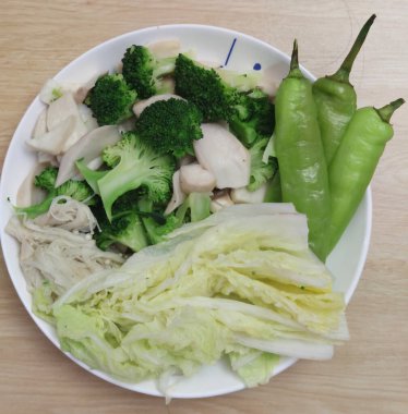 Sağlıklı bir gurme restoranında haşlanmış organik brokoli, Çin lahanası, yeşil biber ve mantar beyazı karışımı bir şey.