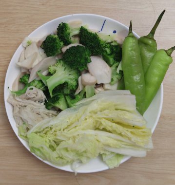 Sağlıklı bir gurme restoranında haşlanmış organik brokoli, Çin lahanası, yeşil biber ve mantar beyazı karışımı bir şey.