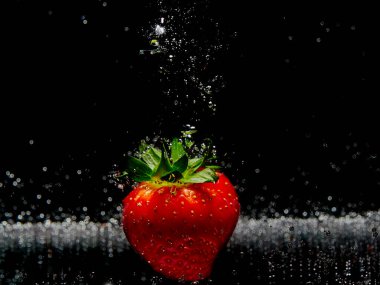 Su olgun tatlı çileğin üzerine damlıyor. Metnin için kopyalama alanı olan taze böğürtlen arka planı. Vegan kavramı. 