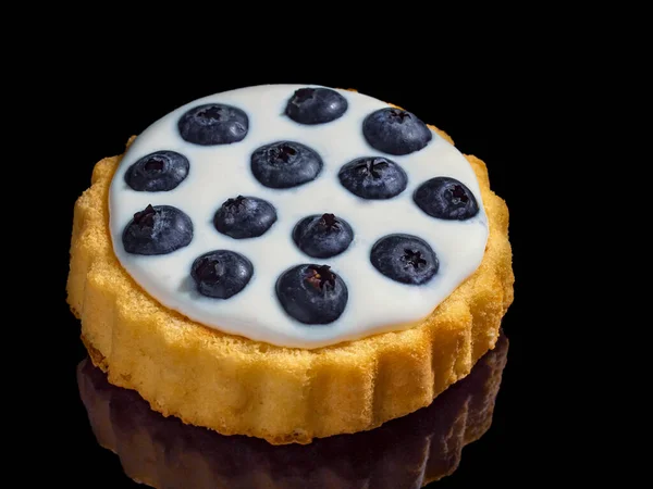Siyah arkaplanda kremalı ve yaban mersinli tart.. 