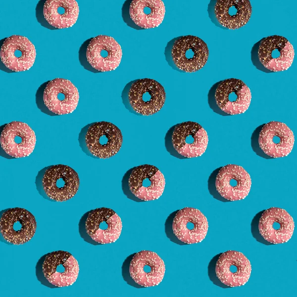 Een Patroon Van Heerlijke Donuts Een Blauwe Achtergrond Bovenaanzicht Vlakke — Stockfoto