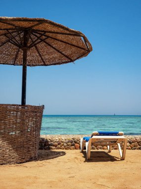 Hurghada sahilinde sandalye ve şemsiye.