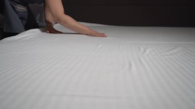 Otel temizliğinin görüntüleri, yatağı temizleyen kadın. 
