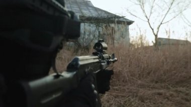 Özel kuvvetler askerleri tarlalardan ve binalardan gizlice geçiyor.