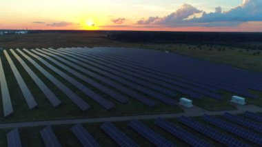 Aeiral. Temiz Enerji Üretimi. Güneş enerjisi panellerinin üzerinden uç. Gün batımı. 4K