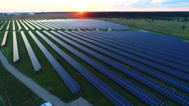 Aeiral. Temiz Enerji Üretimi. Güneş enerjisi panellerinin üzerinden uç. Gün batımı. 4K