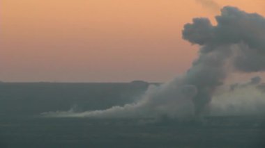 Ateş altındaki savaş alanı: ağır topların bombardımanı. Sabahın erken saatlerinde bombardıman. Bir sürü kabuk ve kalın duman