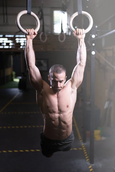 在交叉训练体育馆里练体操圈的肌肉男 — 图库照片