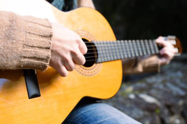 Gitar çalan müzisyenin elinin yakın çekimi.