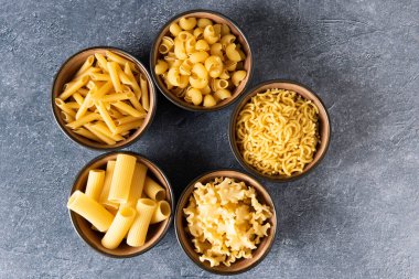Yukarıdan, kaselerdeki makarna çeşitliliğinin görüntüsü