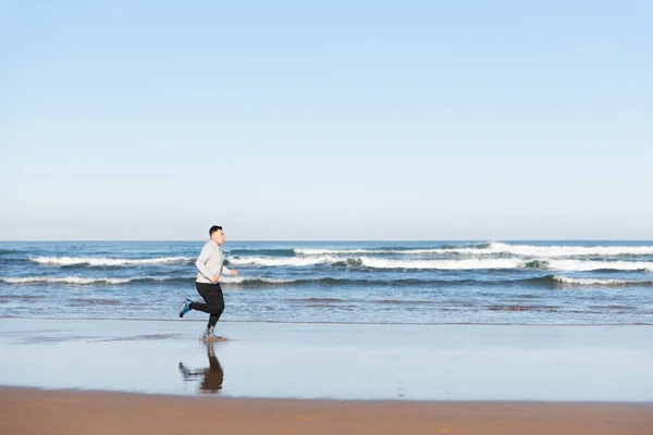 海辺を走るラテン系のスポーツマンは彼の目標に焦点を当てた スポーツモチベーションコンセプト — ストック写真