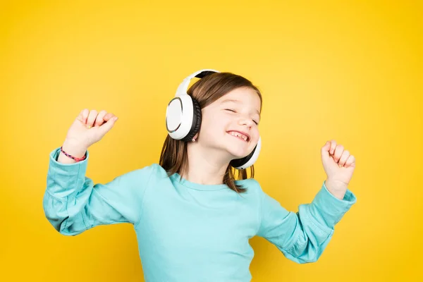 幸せな小さな子供は音楽を聞いて 閉じた目でファンキーに踊る — ストック写真