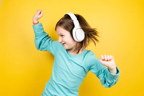 小さな女の子リスニング音楽とダンスファンキーで黄色の背景 — ストック写真
