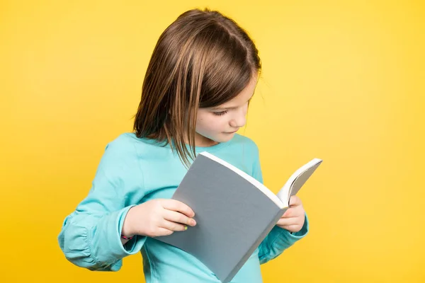 Liten Flicka Läser Bok Gul Bakgrund — Stockfoto