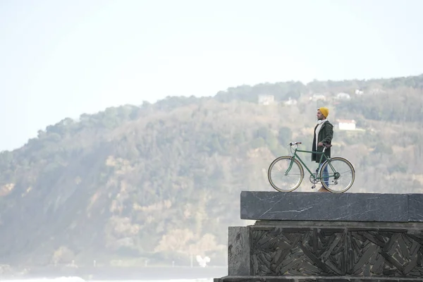 風景を眺めながら壁に自転車を持つ観光客 — ストック写真