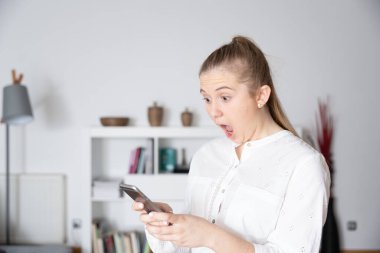 Genç bir kadın telefonuna bakarken şoka giriyor. Kripto para birimi veya borsa konsepti üzerinde kötü sonuçlar