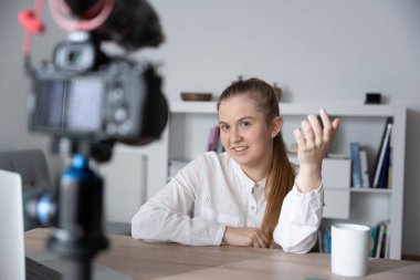 Nüfuzlu biri kameraya konuşuyor. Genç içerik yaratıcısı evde ders kaydı yapıyor.