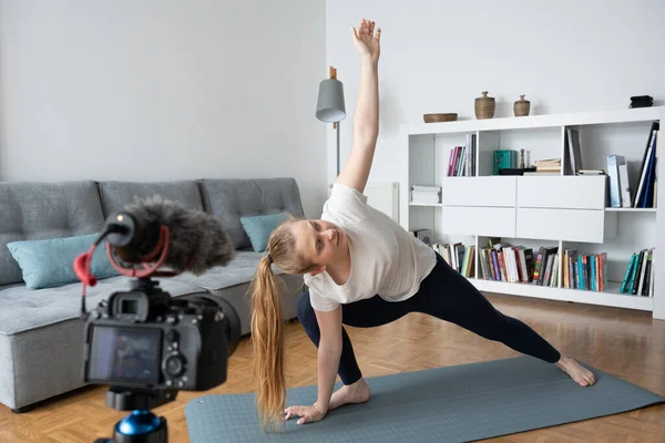 Yoga eğitmeni evde profesyonel kamerayla bir ders kaydediyor..