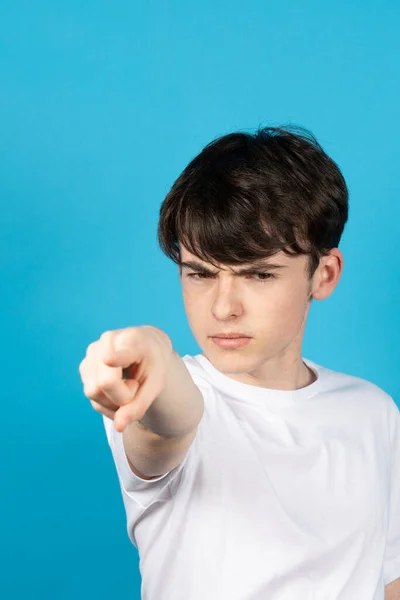 Teenager Chlapec Ukazuje Přímo Kameru Modrém Pozadí — Stock fotografie