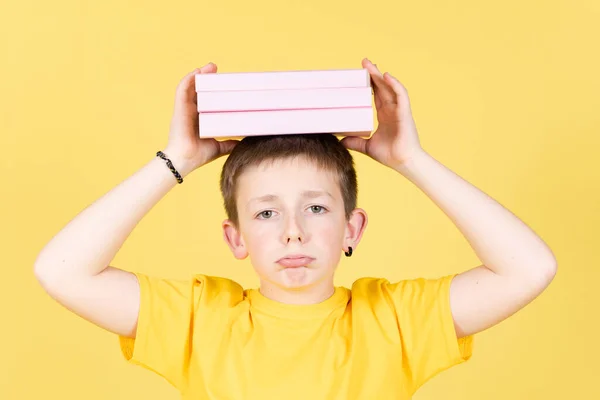 Cute Bored Boy Holding Pile Books His Head Isolated Yellow — ストック写真