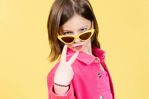 Arrogant Little Girl Wearing Sunglasses Posing Camera Isolated Yellow Background — ストック写真