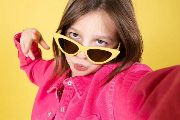 Arrogant Little Girl Wearing Sunglasses Taking Selfie Isolated Yellow Background — ストック写真
