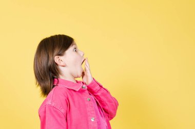 Şaşırmış küçük kızın el ele verip sarı fotokopi odasına bakışları.