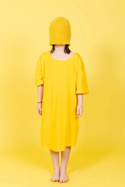 子供の頃の概念に対する不安 うつ病やストレスの抽象的な概念 小さな女の子の上に身に着けていますサイズシャツと目隠し付き帽子黄色の背景に隔離された — ストック写真