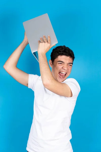 Angry Desperated Hispanic Teenager Boy Throwing Computer Isolated Blue Background —  Fotos de Stock