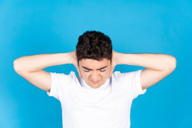 Yoksul İspanyol ergen çocuk mavi arka planda izole edilmiş anksiyete sıkıntısı çekiyor..