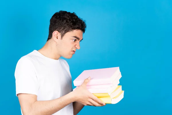 Adolescente Hispânico Menino Olhando Com Rosto Repugnante Pilha Livros Isolados — Fotografia de Stock