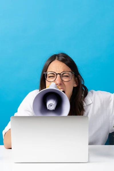 Angry Hispanic Woman Shouting Megaphone Front Laptop Isolated Blue Background — Stock Fotó