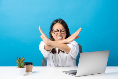 Laptopun önünde el kol hareketi yapan negatif İspanyol iş kadını mavi arka planda izole edilmiş..