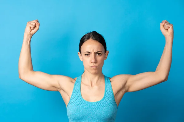 Focused Sportive Hispanic Young Woman Showing Biceps Isolated Blue Background — Photo