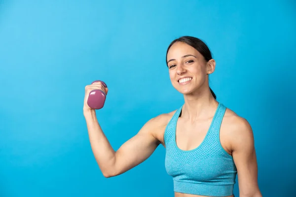 Smiling Sportswoman Looking Camera Rising Weights Isolated Blue Background Fit — Fotografia de Stock