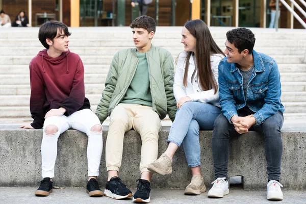 Group Teenagers Talking Sitting Outdoors Bench — Zdjęcie stockowe
