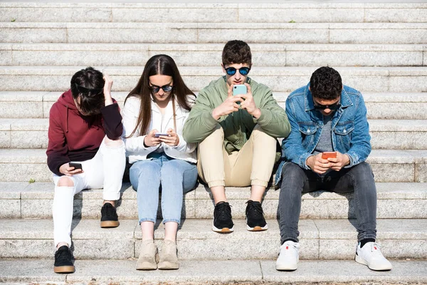 Sekelompok Remaja Duduk Tangga Dan Berkonsentrasi Pada Ponsel Mereka Konsep — Stok Foto