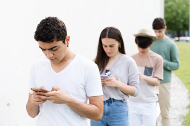 İspanyol ergen çocuk kuyrukta telefona yoğunlaşmıştı. Dijital bağımlılık ve sosyal uzaklık kavramı.