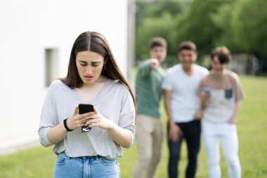 Arkadaşları ona gülerken genç kızın telefona bakmasına şaşırdım. Siber zorbalık kavramı.