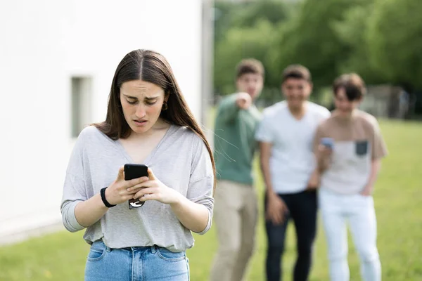 Chica Adolescente Sorprendida Mirando Teléfono Mientras Los Amigos Ríen Ella — Foto de Stock