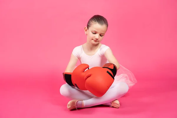 ピンクの背景に隔離されたボクシングの手袋を身に着けている小さな古典的なダンサーの女の子 女性の固定観念 — ストック写真