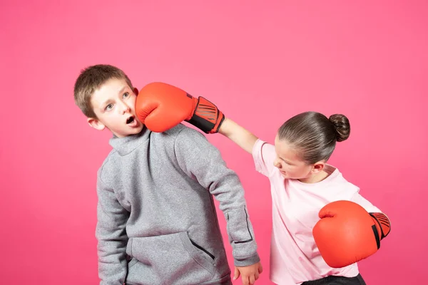 Klein Meisje Draagt Bokshandschoenen Slaat Pestkop Jongen Geïsoleerd Roze Achtergrond — Stockfoto