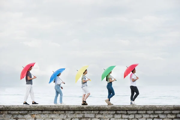 Group Teenagers Walking Wall Holding Colorful Umbrellas Copy Space Sky — Stockfoto