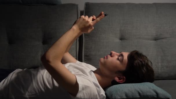 Teenager Boy Text Messaging Phone While Laying Sofa — Stock video