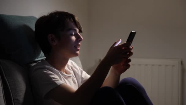 Teenager Boy Taking Phone Answering Text Message Sitting Couch Night — Vídeo de stock