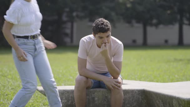 Friends Comforting Sad Hispanic Teenager Boy Outdoors Park Mourning Sadness — Αρχείο Βίντεο