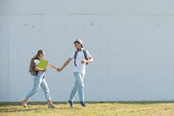 Teenager Students Couple Running Holding Hands Copy Space Concrete Wall — Stockfoto