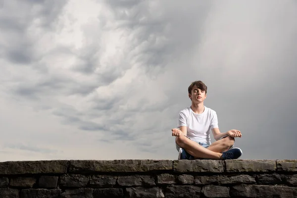 Cute Teenager Boy Meditating Dramatic Stormy Sky Calm Adversity Situation — Stok fotoğraf